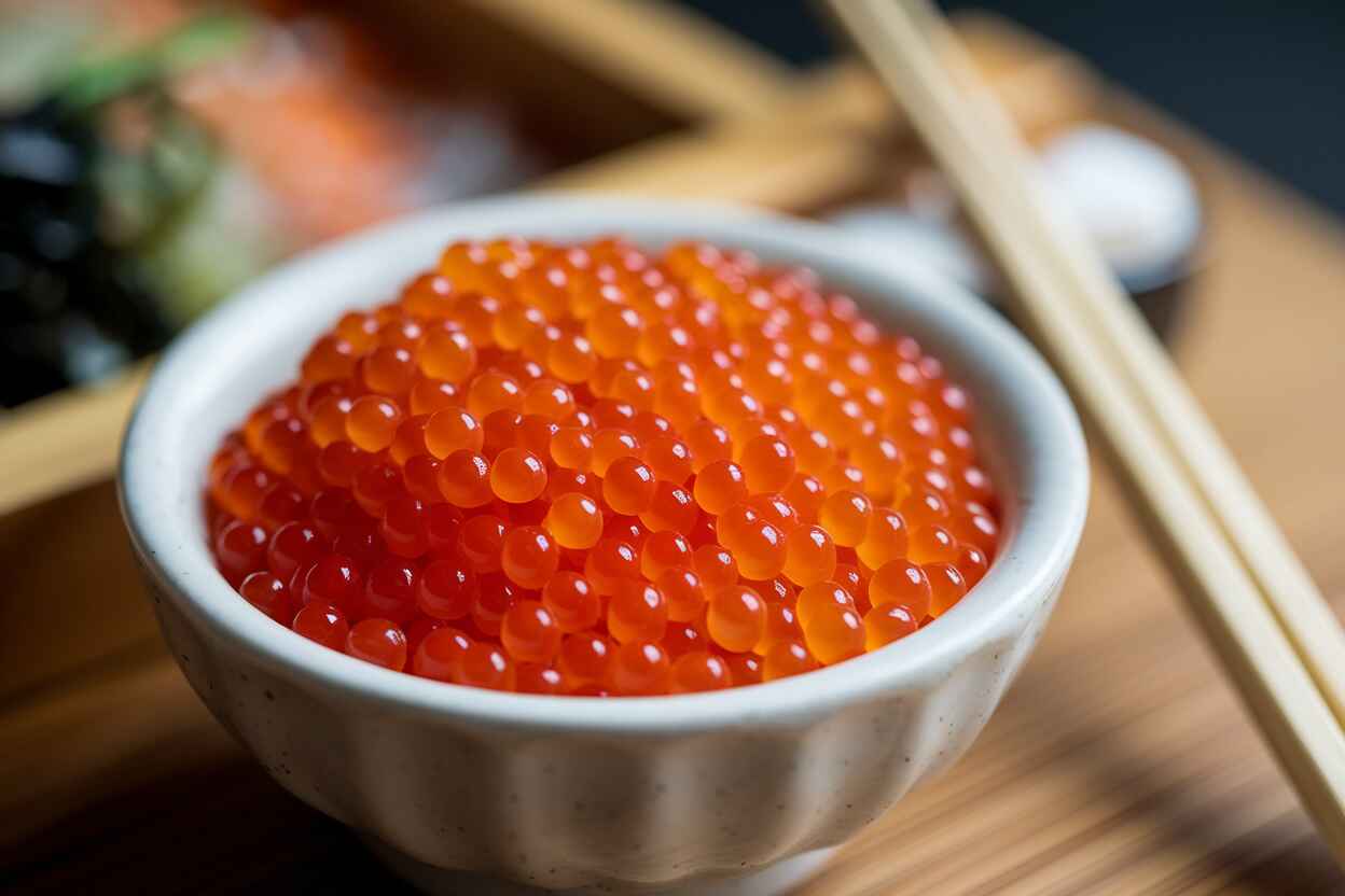 A bowl of fresh orange tobiko sushi roe