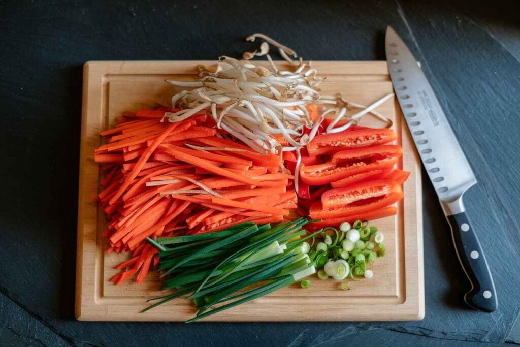 Freshly sliced carrots, bell peppers, bean sprouts, and green onions for Chicken Mei Fun.